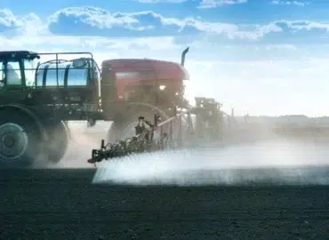 Agente antideriva sendo aplicado em pulverização agrícola com formação de gotas uniformes